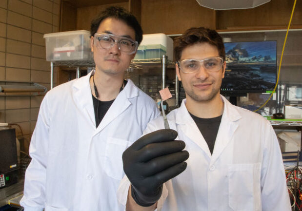 MIE PhD students Rui Kai (Ray) Miao (left) and Panos Papangelakis (right) hold up a new catalyst they designed to convert captured CO2 gas into valuable products. Their version performs well even in the presence of sulphur dioxide, a contaminant that poisons other catalysts. (photo by Tyler Irving)